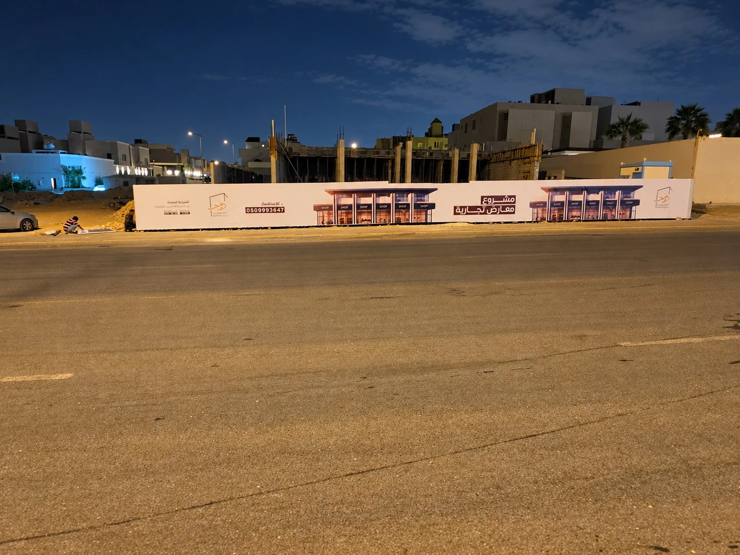 سور مشروع إعلاني لمعارض تجارية في حي النرجس بالرياض مغلّف ببنر بهوية المشروع – تنفيذ أركون لأسوار المشاريع